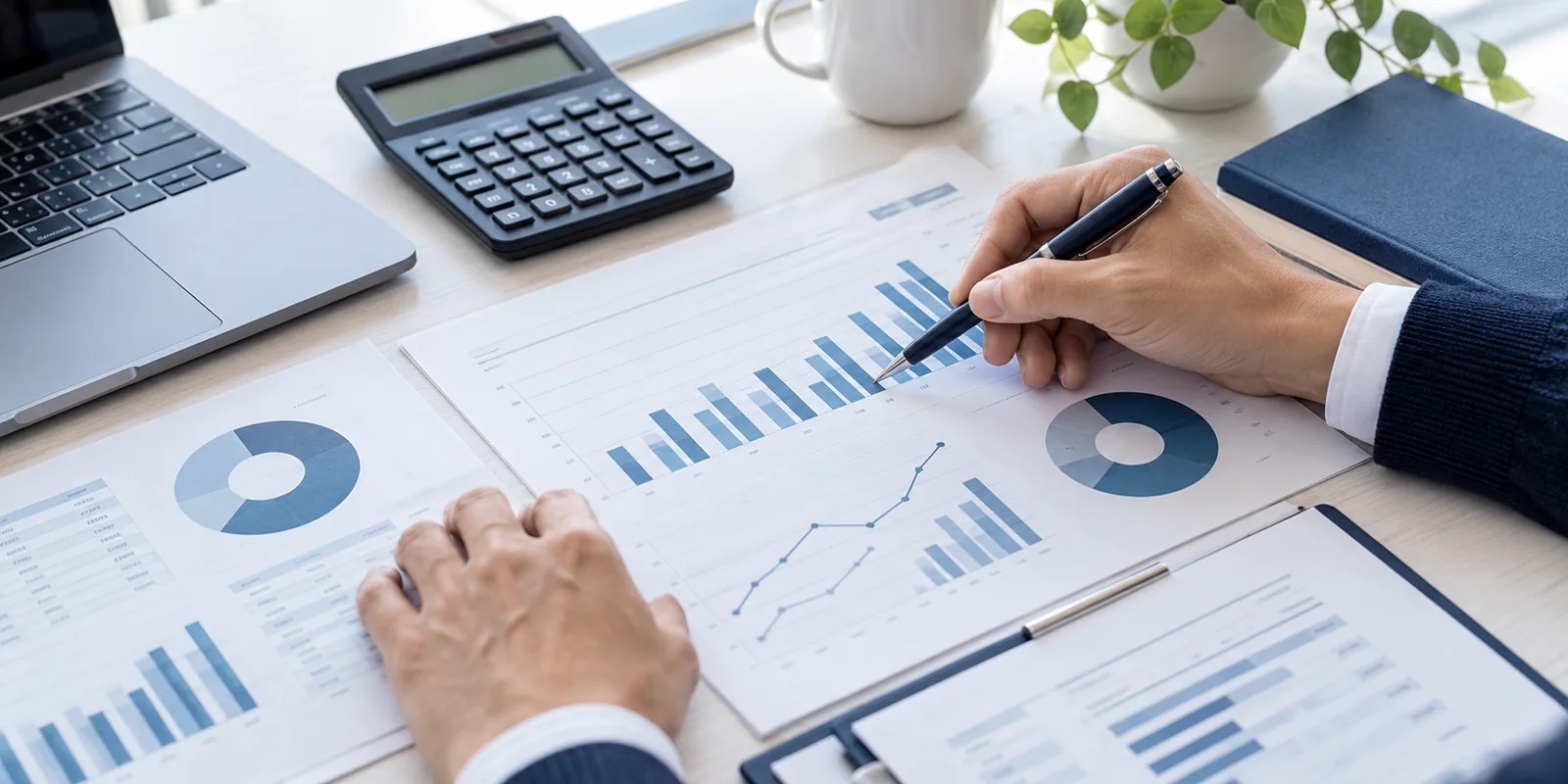 Close-up of hands reviewing financial documents with a pen and calculator